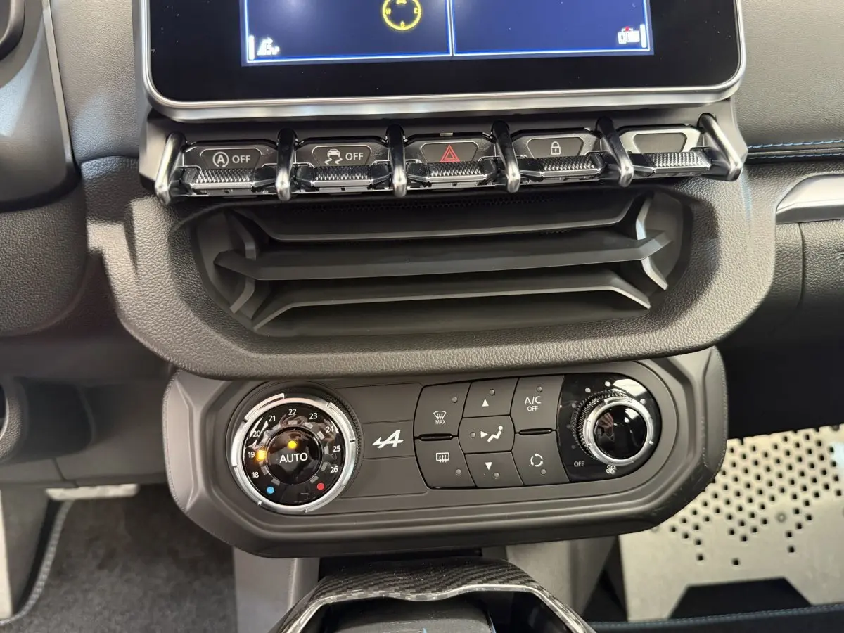 Vue rapprochée du tableau de bord noir de l'Alpine A110 Legende 2019 avec commandes climatisation et écran tactile.