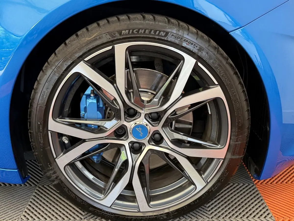 Gros plan sur la roue avant droite bleue d'une Alpine A110 Legende 2019 avec étrier de frein assorti.