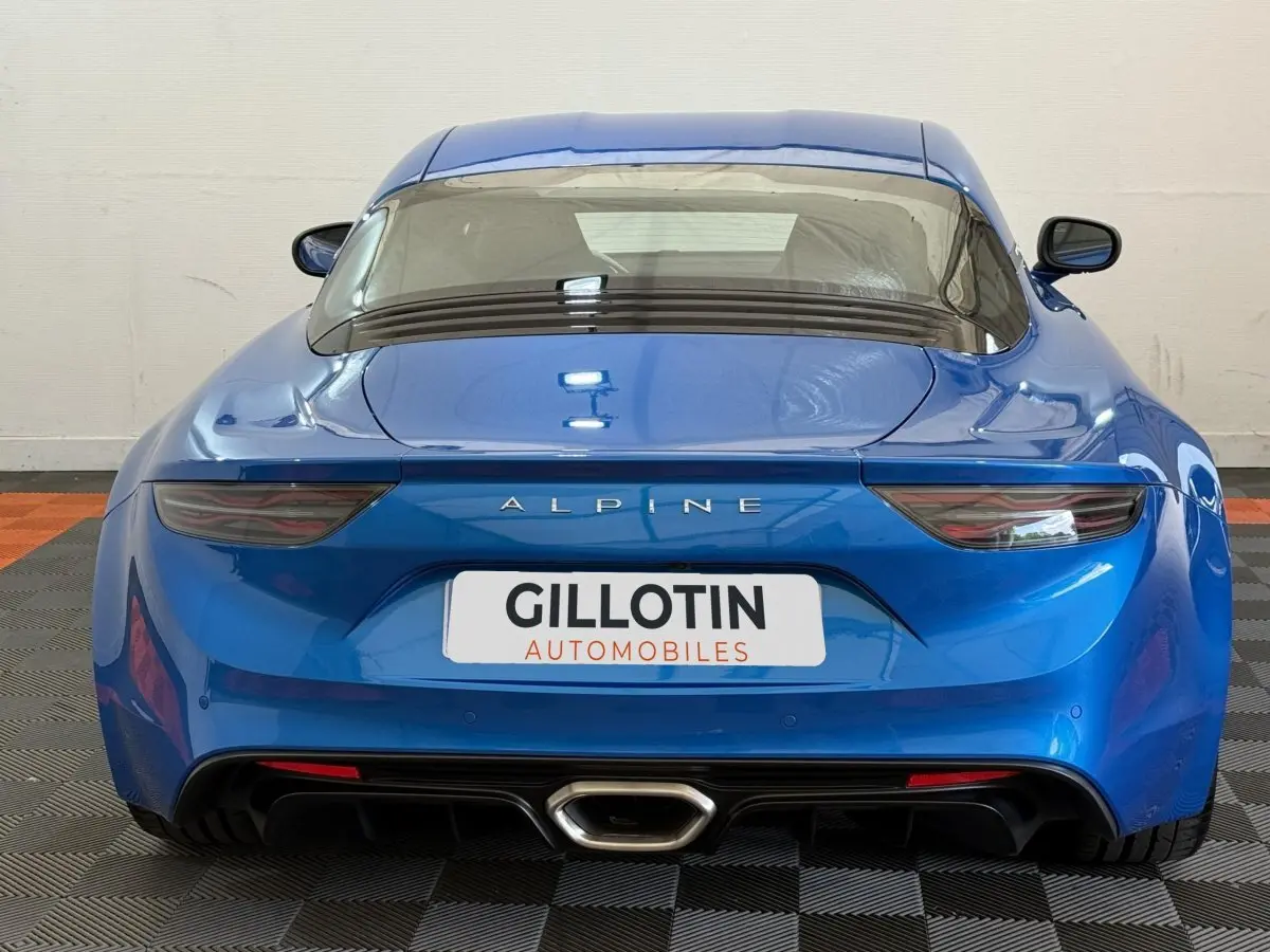 Vue arrière d'une Alpine A110 Legende bleu brillant, mettant en valeur ses feux effilés et son échappement central.