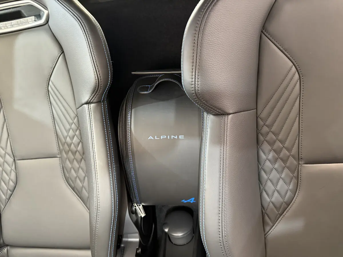 Gros plan sur les sièges en cuir gris avec surpiqûres bleues et sac Alpine entre les sièges de l'Alpine A110 Legende 2019.