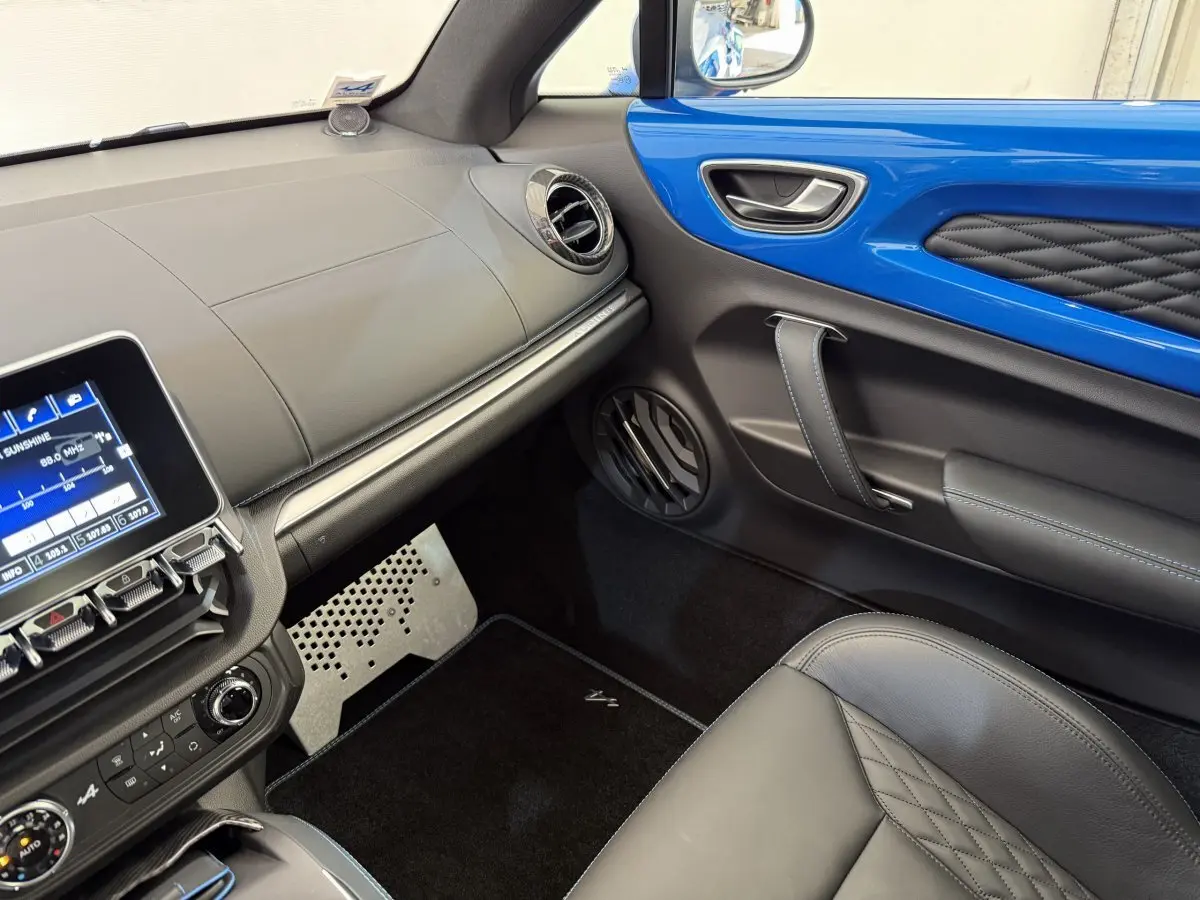 Intérieur de l'Alpine A110 Legende 2019, vue côté passager, avec garniture bleue et sièges cuir noir matelassé.