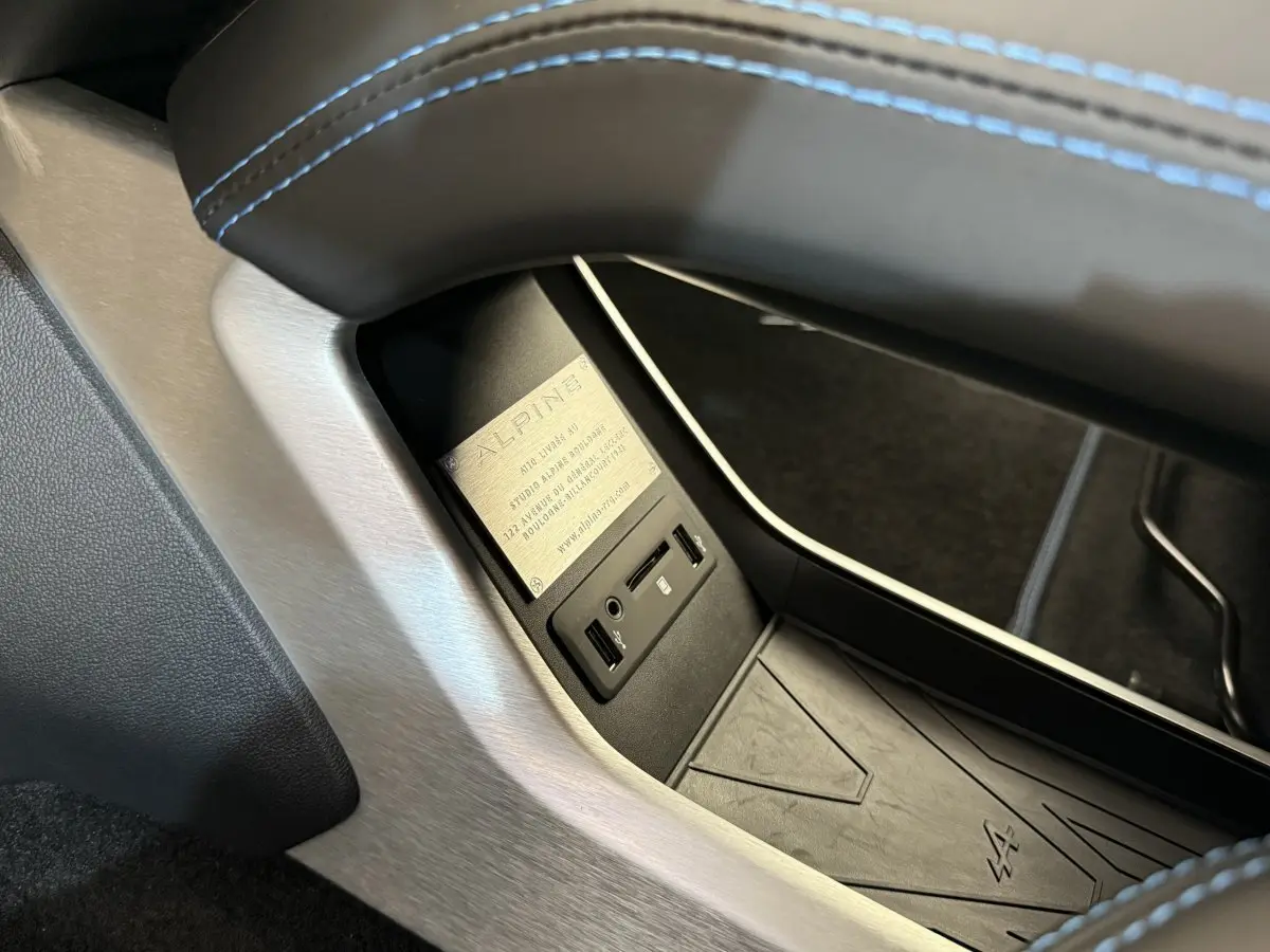Gros plan sur la console centrale intérieure de l'Alpine A110 Légende 2019 avec surpiqûres bleues et plaque Alpine.