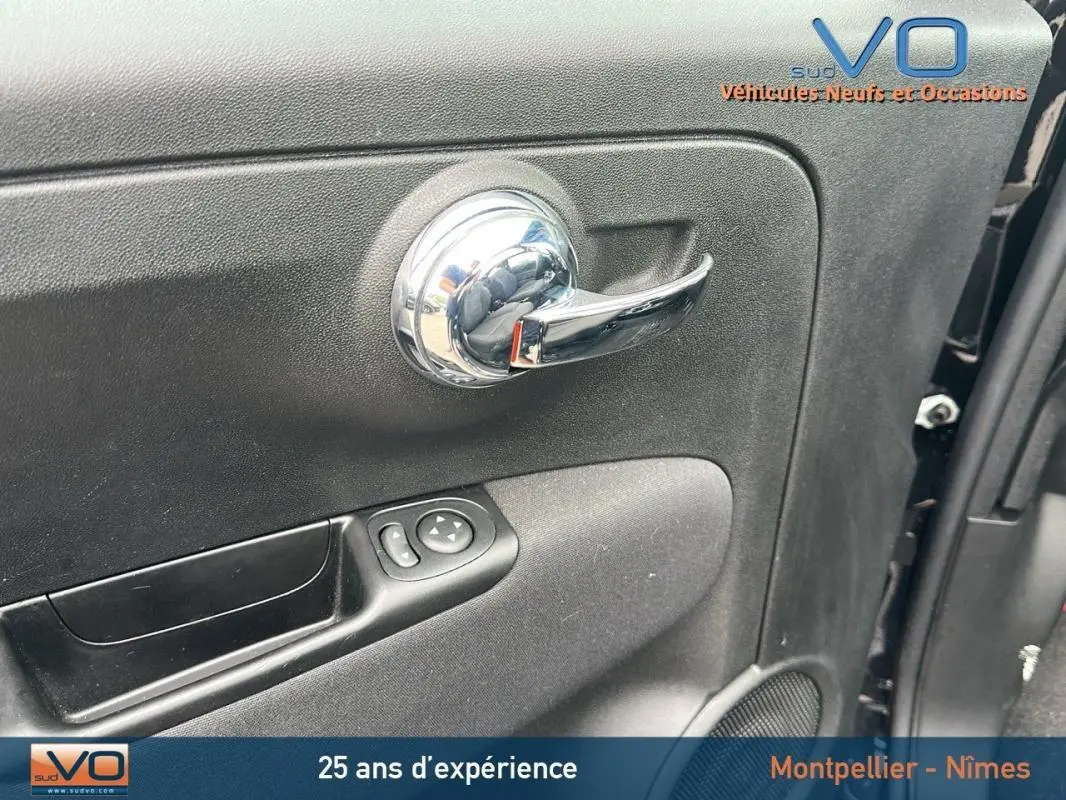 Poignée de porte intérieure chromée côté gauche d'une FIAT 500C noire 2024 avec commandes de vitre et haut-parleur.