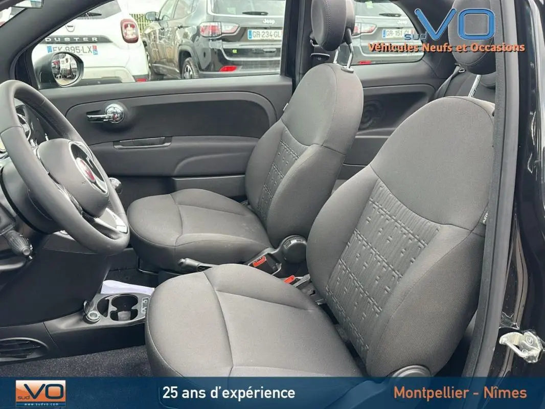 Vue intérieure côté droit montrant les sièges avant gris et le volant d'une FIAT 500C noire de 2024.