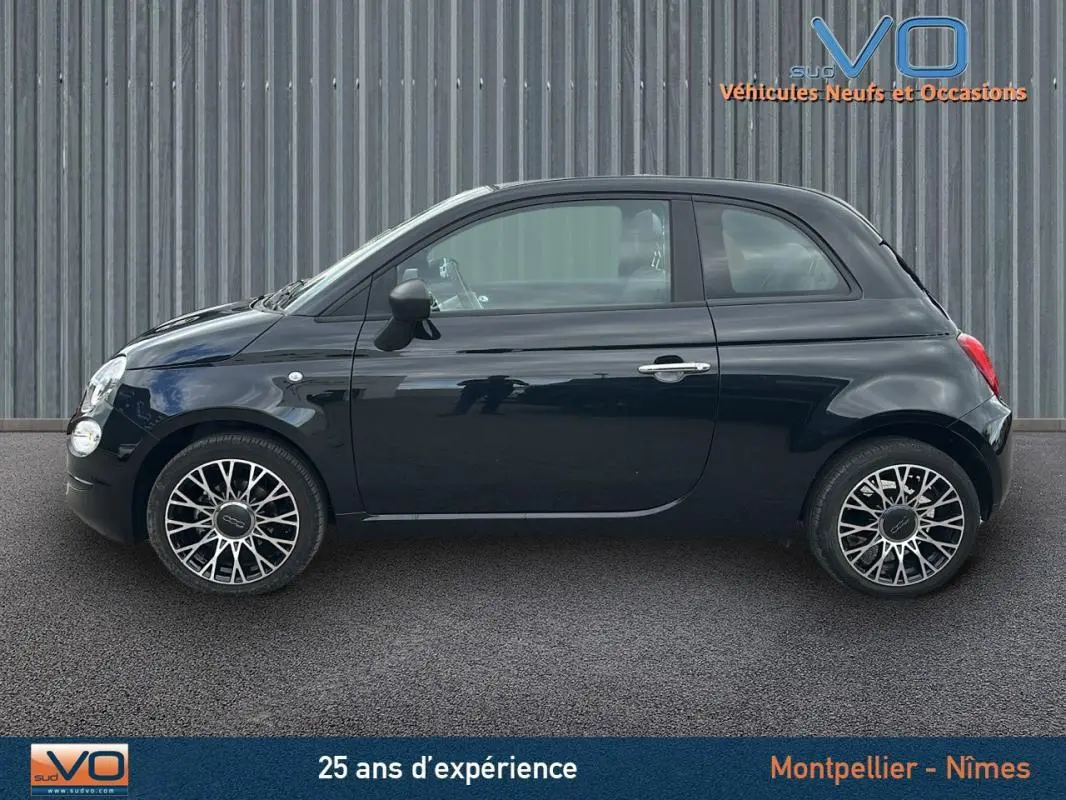 Profil côté gauche d'une FIAT 500C noire 2024 avec jantes stylisées et roue de secours visible.