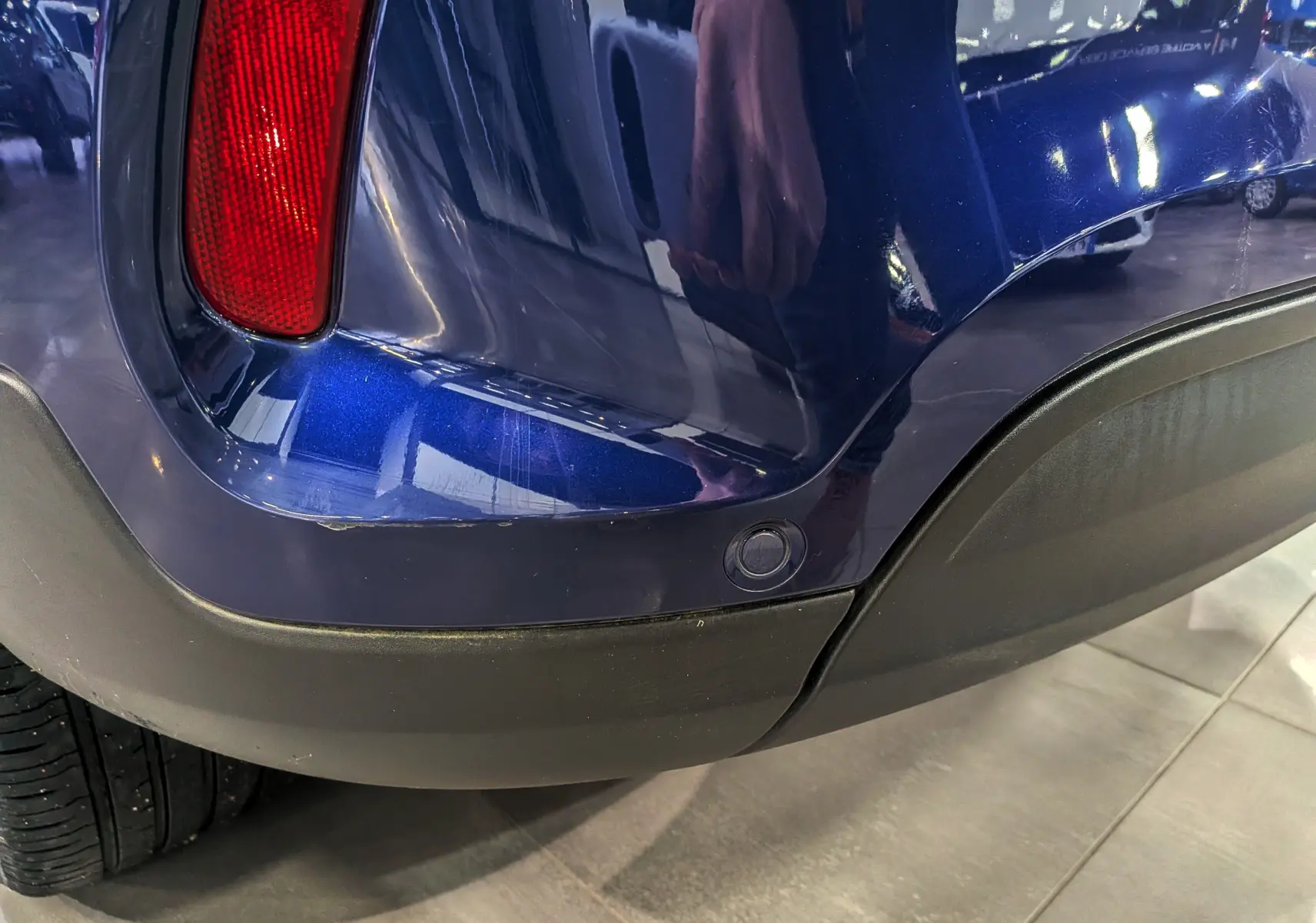 Détail du pare-chocs arrière droit bleu Venezia de la FIAT 500X 2024 avec feu rouge et capteur de stationnement.