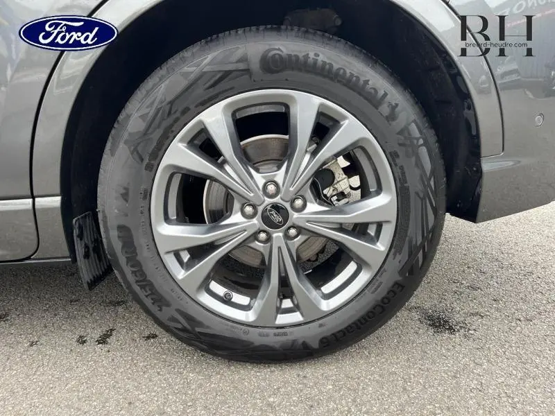 Gros plan sur la roue avant gauche du Ford Kuga gris Magnetic Métallisé avec jante alu et pneu Continental.