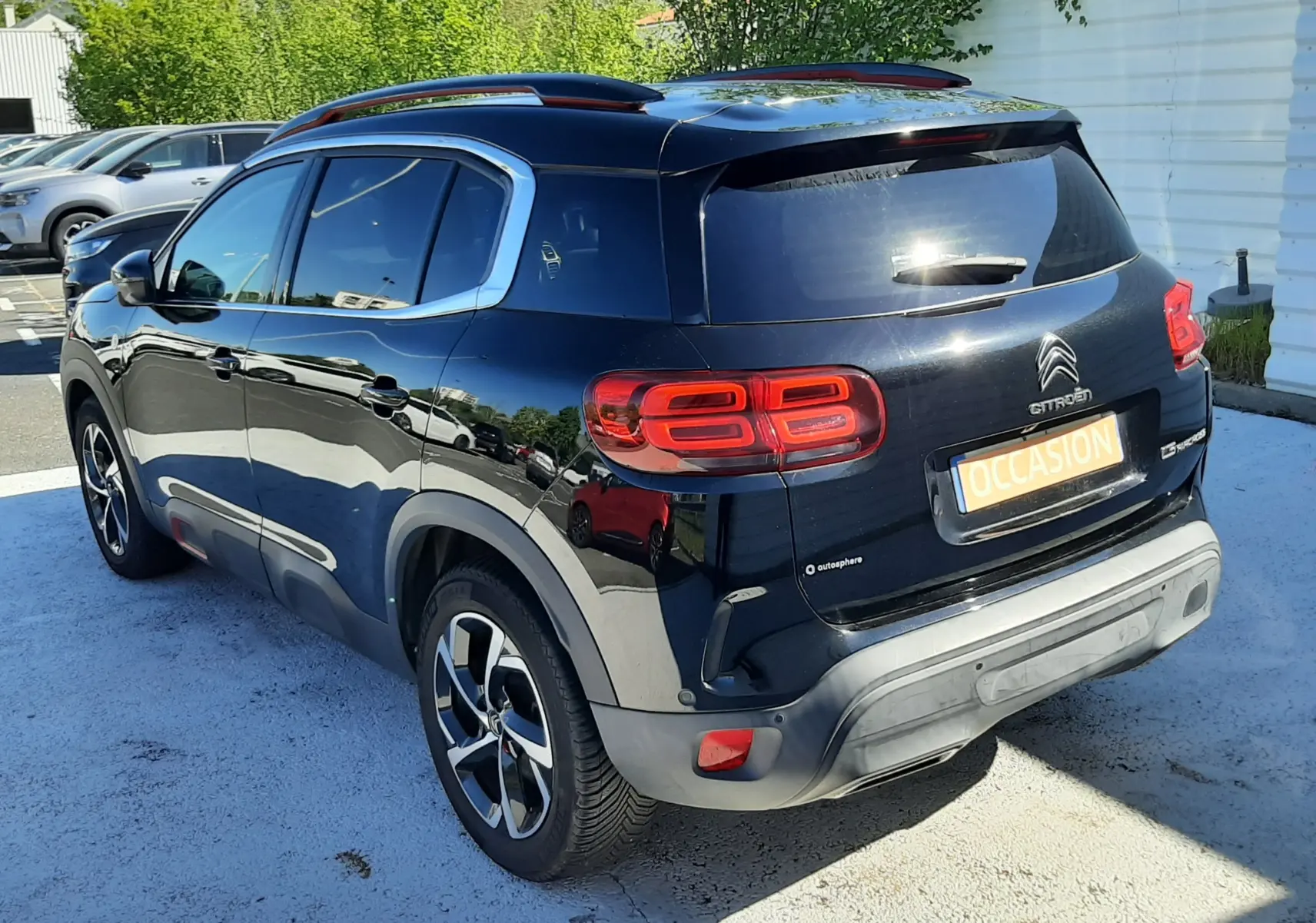 Vue 3/4 arrière droite d'un Citroën C5 Aircross noir 2020 avec feux arrière distinctifs et toit ouvrant panoramique.