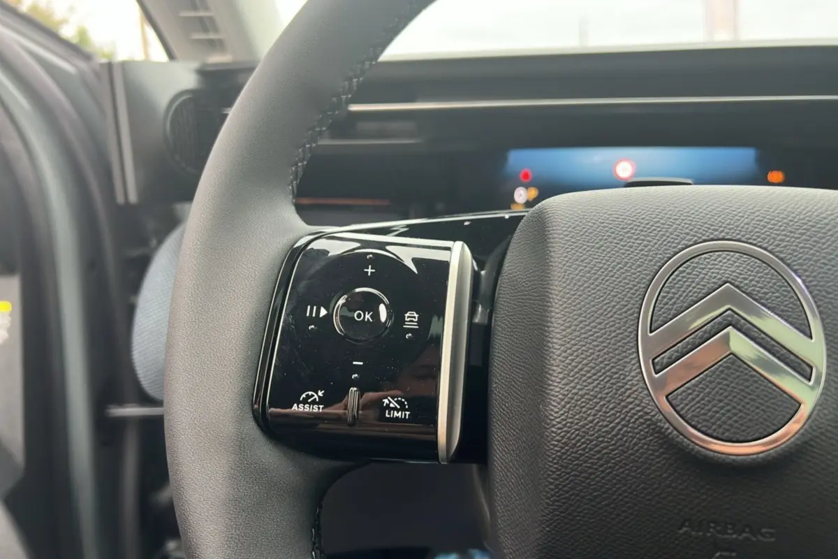 Gros plan sur le volant cuir multifonctions du Citroën C5 Aircross New Hybrid 145 Max T.O, logo chrome visible.