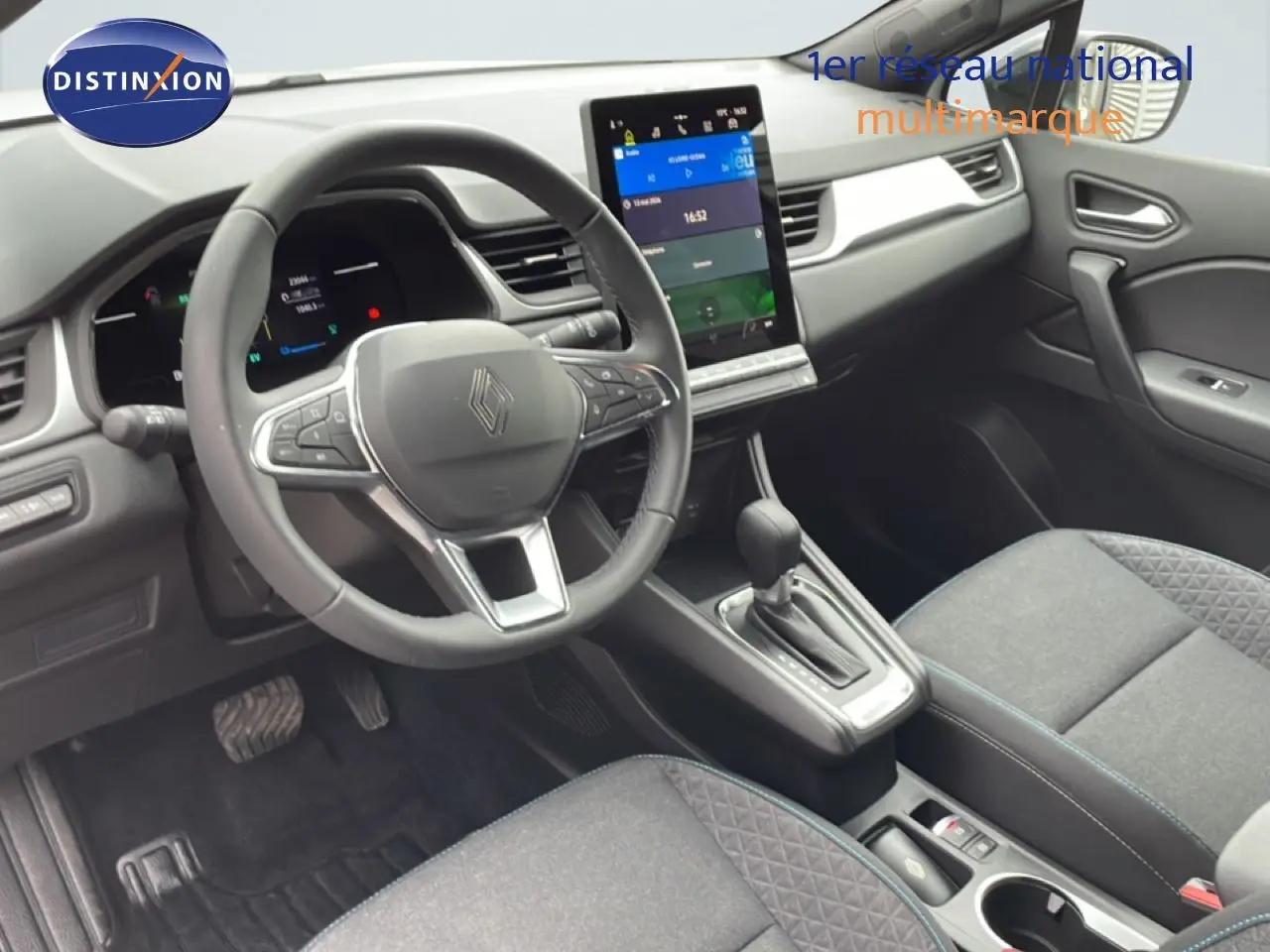 Vue intérieure avant de la Renault Symbioz E-Tech Full Hybrid 2025, tableau de bord moderne avec écran tactile vertical et volant cuir.