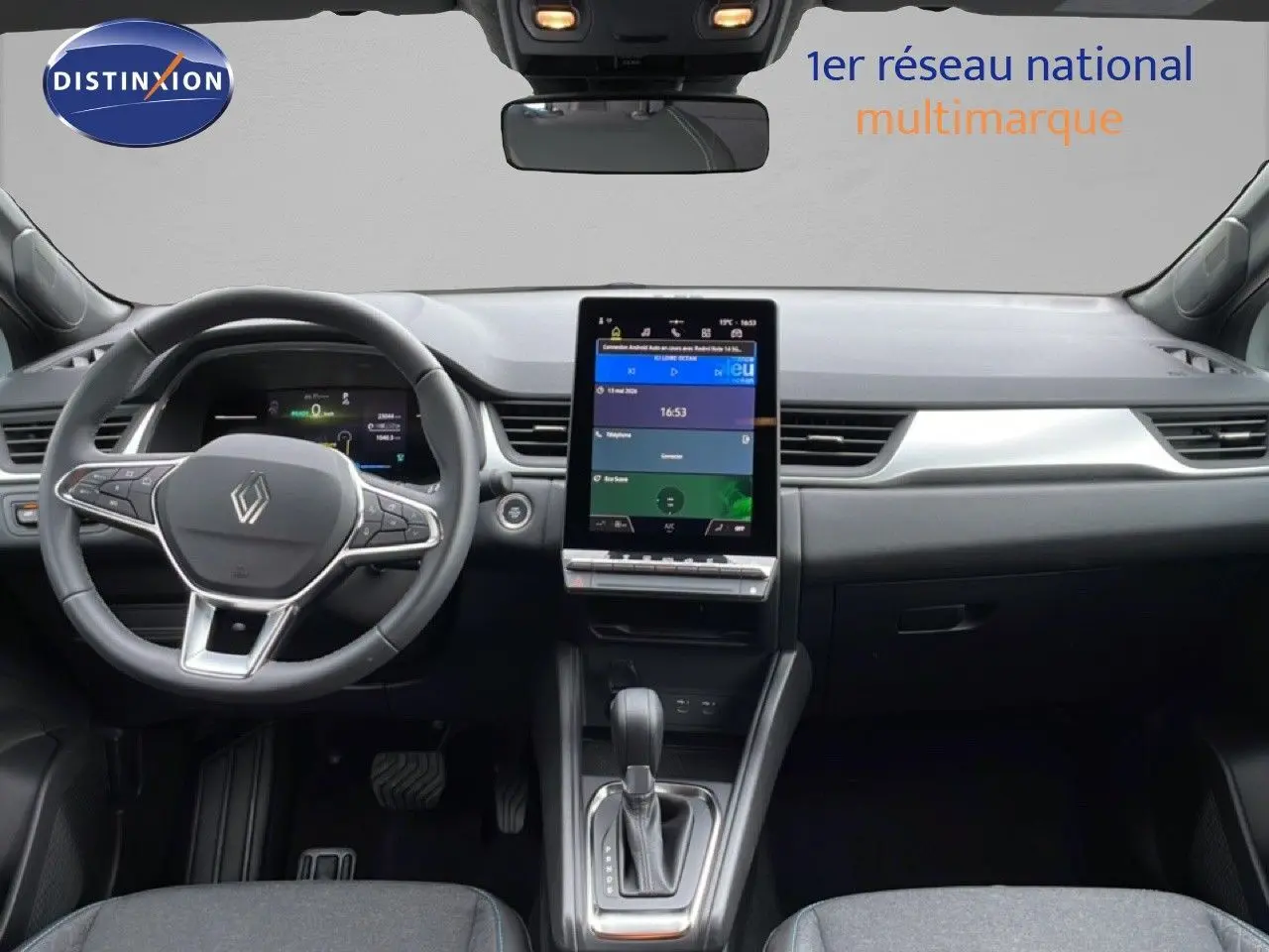 Vue intérieure avant du tableau de bord et volant du Renault Symbioz blanc nacré, avec écran tactile central vertical.