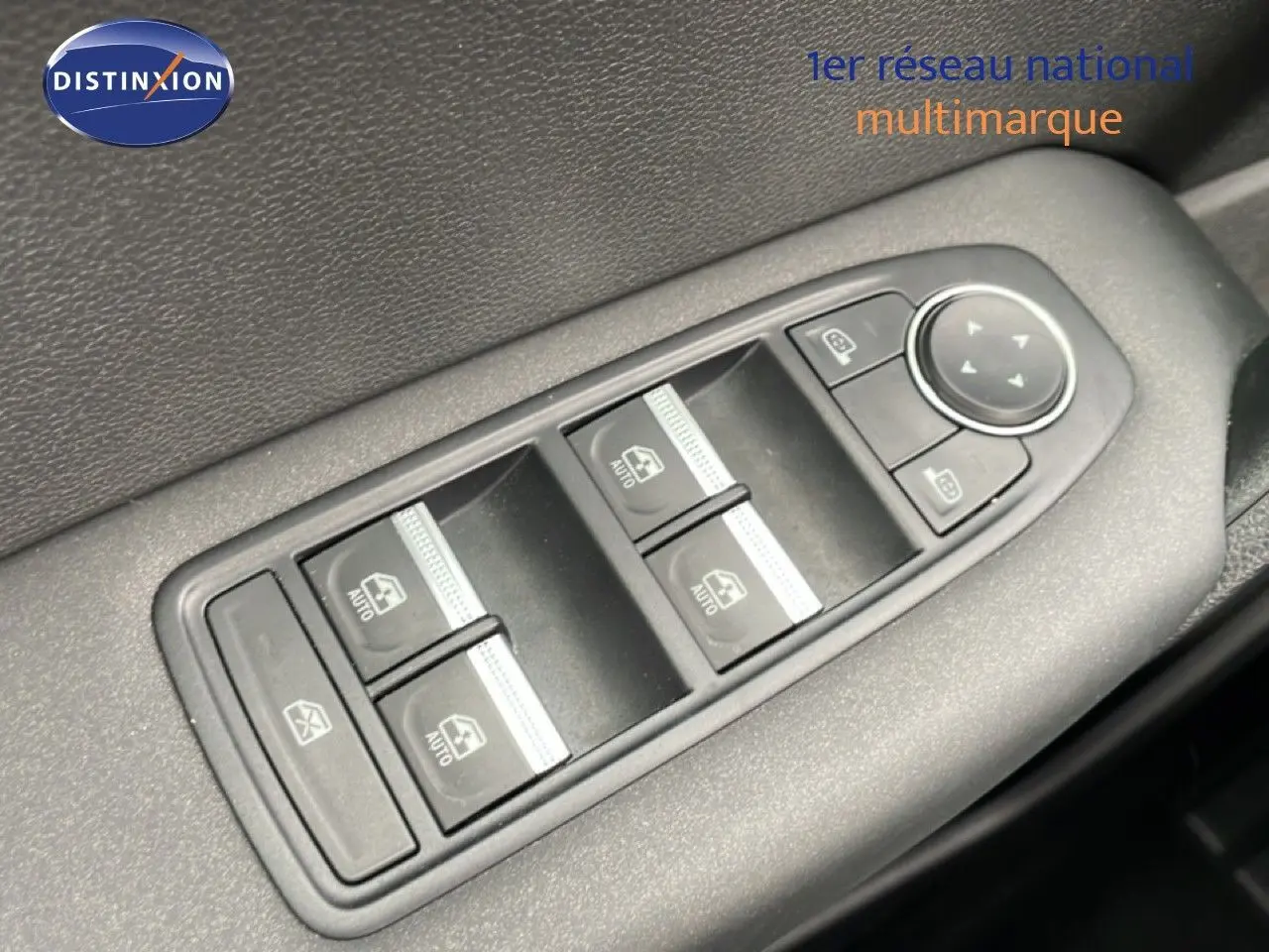 Gros plan sur les commandes des vitres électriques et des rétroviseurs côté conducteur d'une Renault Symbioz blanc nacré.