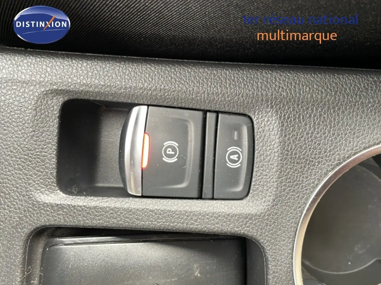 Vue rapprochée sur les commandes de frein à main électronique et auto hold dans l’habitacle d’une Renault Symbioz blanc nacré.