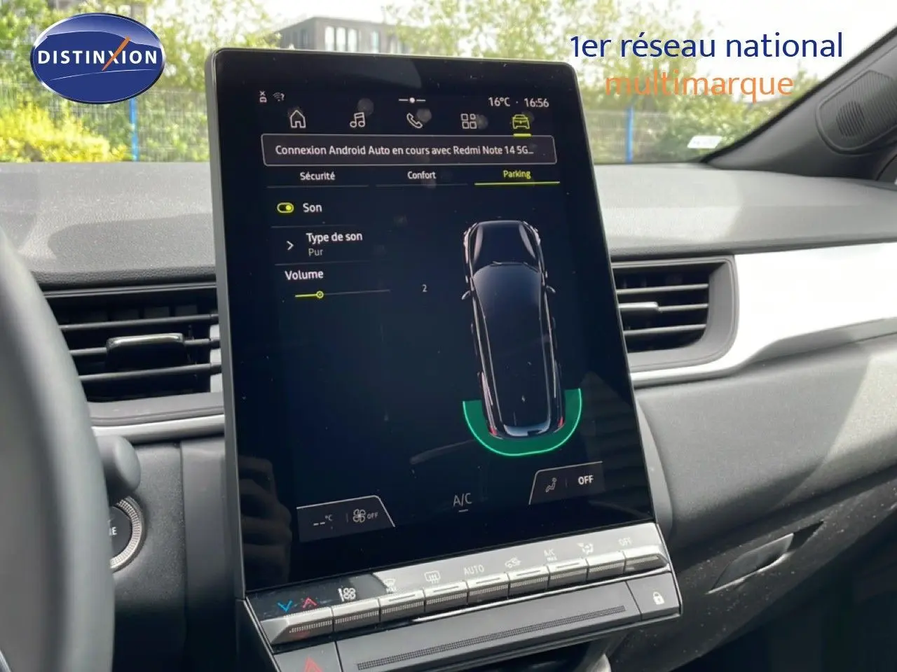 Vue intérieure du tableau de bord de la Renault Symbioz blanc nacré, écran tactile central affichant l'aide au stationnement.