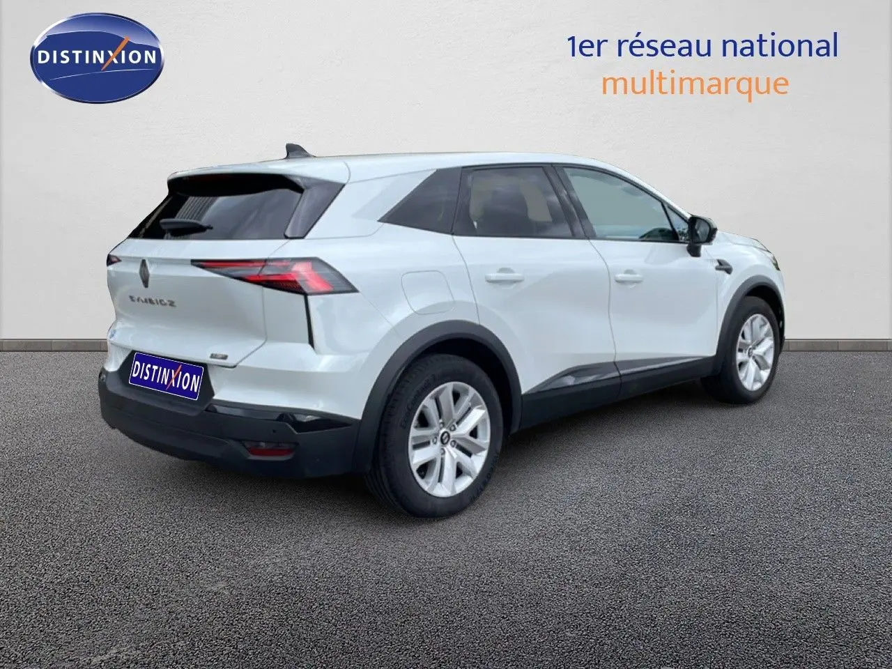 Vue 3/4 arrière droite d’un Renault Symbioz blanc nacré avec détails noirs et jantes argentées sur fond neutre.