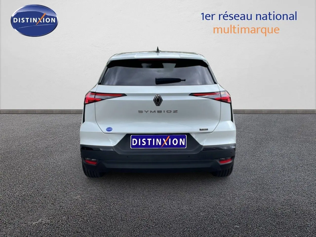 Vue arrière d'une Renault Symbioz blanc nacré métal, avec feux arrière étirés et logo central bien visible.
