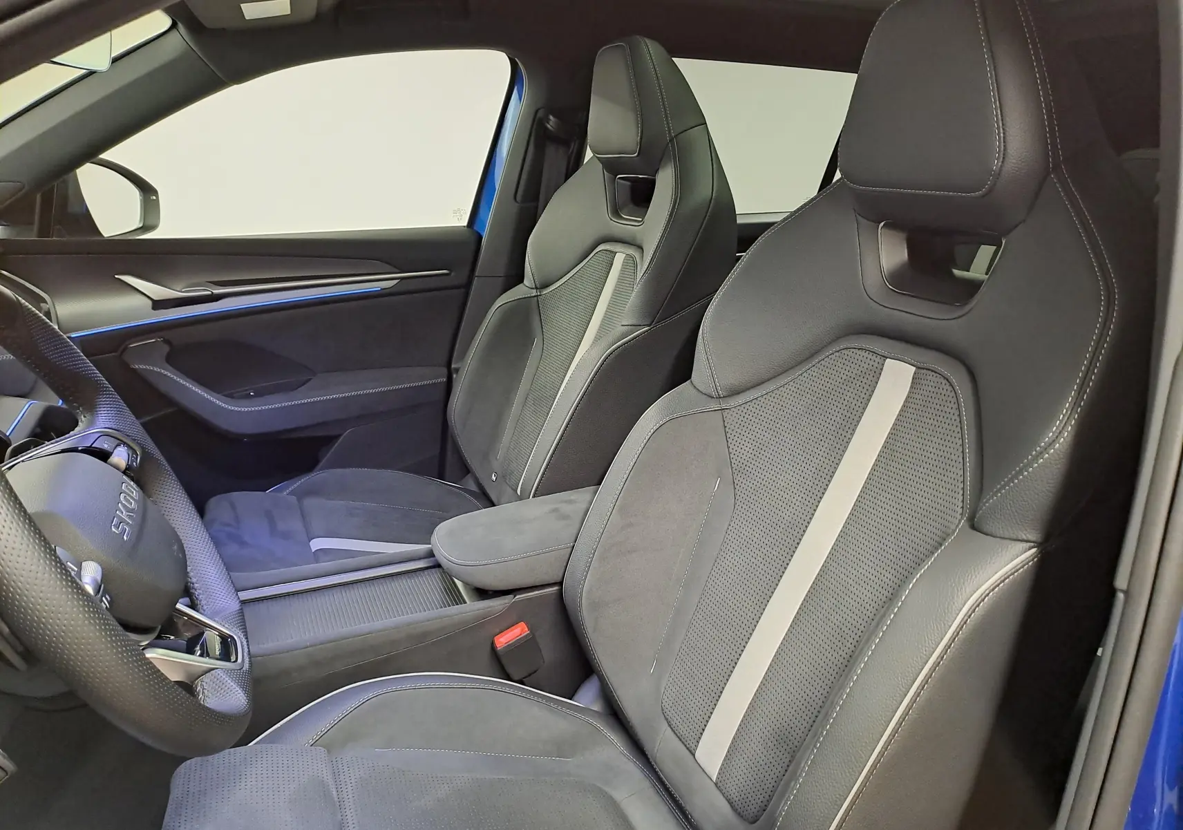 Vue intérieure côté conducteur du Skoda Kodiaq Bleu RS 2025, sièges sport en cuir et alcantara avec surpiqûres contrastées.