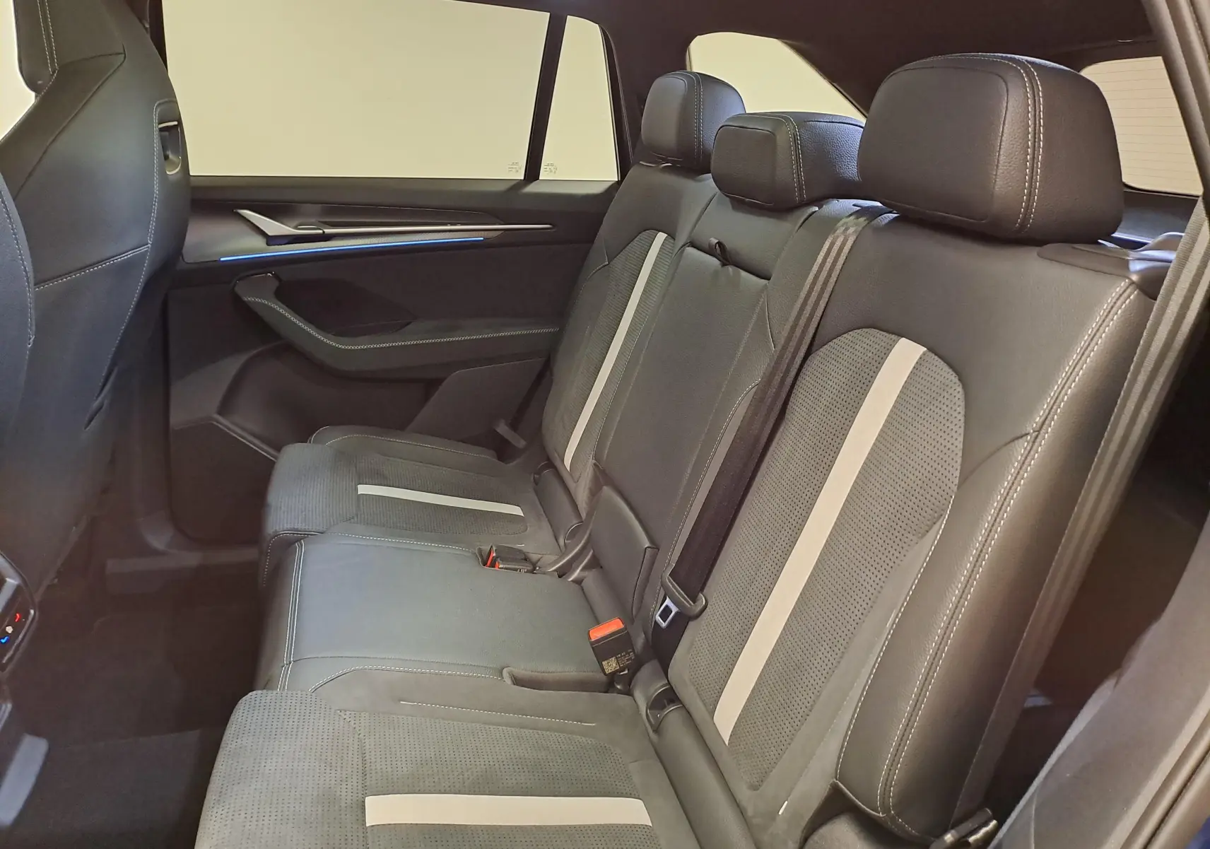 Vue intérieure côté droit des sièges arrière en cuir noir avec surpiqûres blanches du Skoda Kodiaq 2025 Sportline.