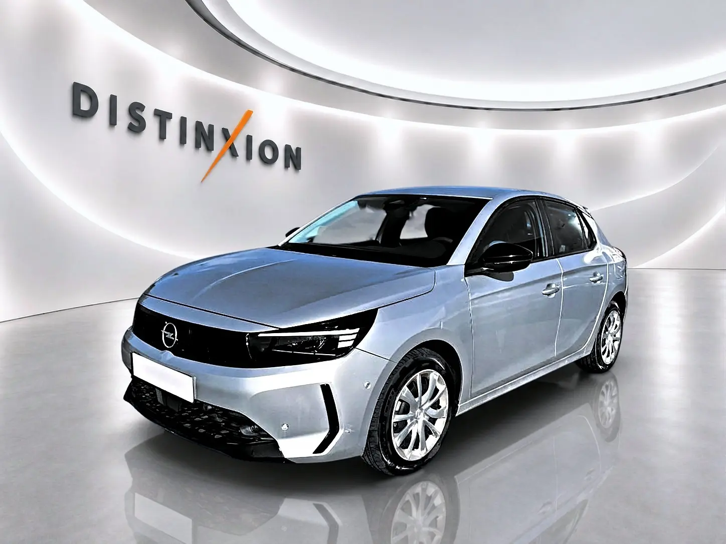 Opel Corsa gris 3/4 avant droit en showroom avec calandre noire et jantes argentées.