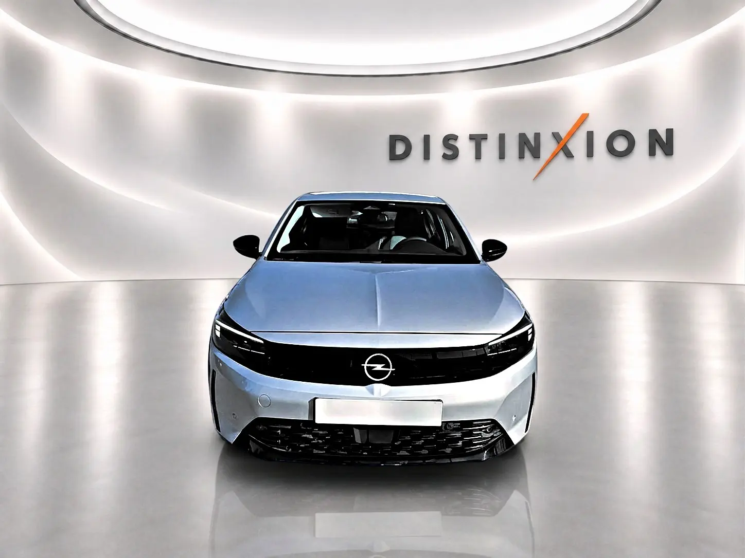 Vue avant d'une Opel Corsa gris clair 2025 avec calandre noire et logo Opel au centre, dans un studio lumineux.