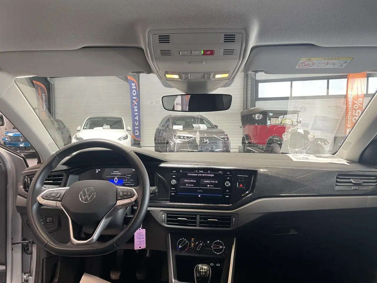 Vue intérieure avant du tableau de bord et volant cuir multifonction de la Volkswagen Polo gris clair 2024.
