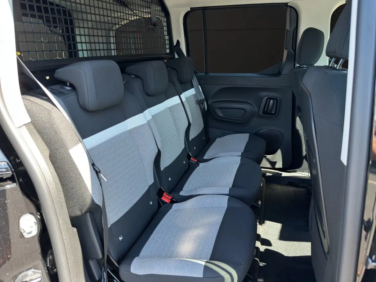 Vue latérale intérieure sur la banquette arrière grise et noire du Citroën Berlingo noir avec séparation métallique.