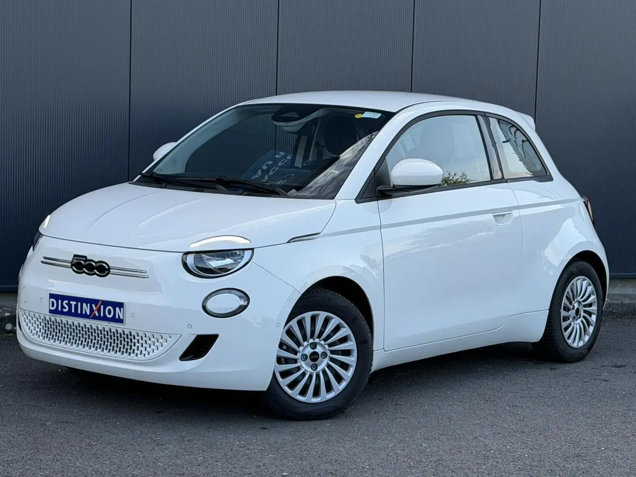 Fiat 500 électrique blanc Artic vue 3/4 avant droit, avec logo 500 noir et jantes multibranches.
