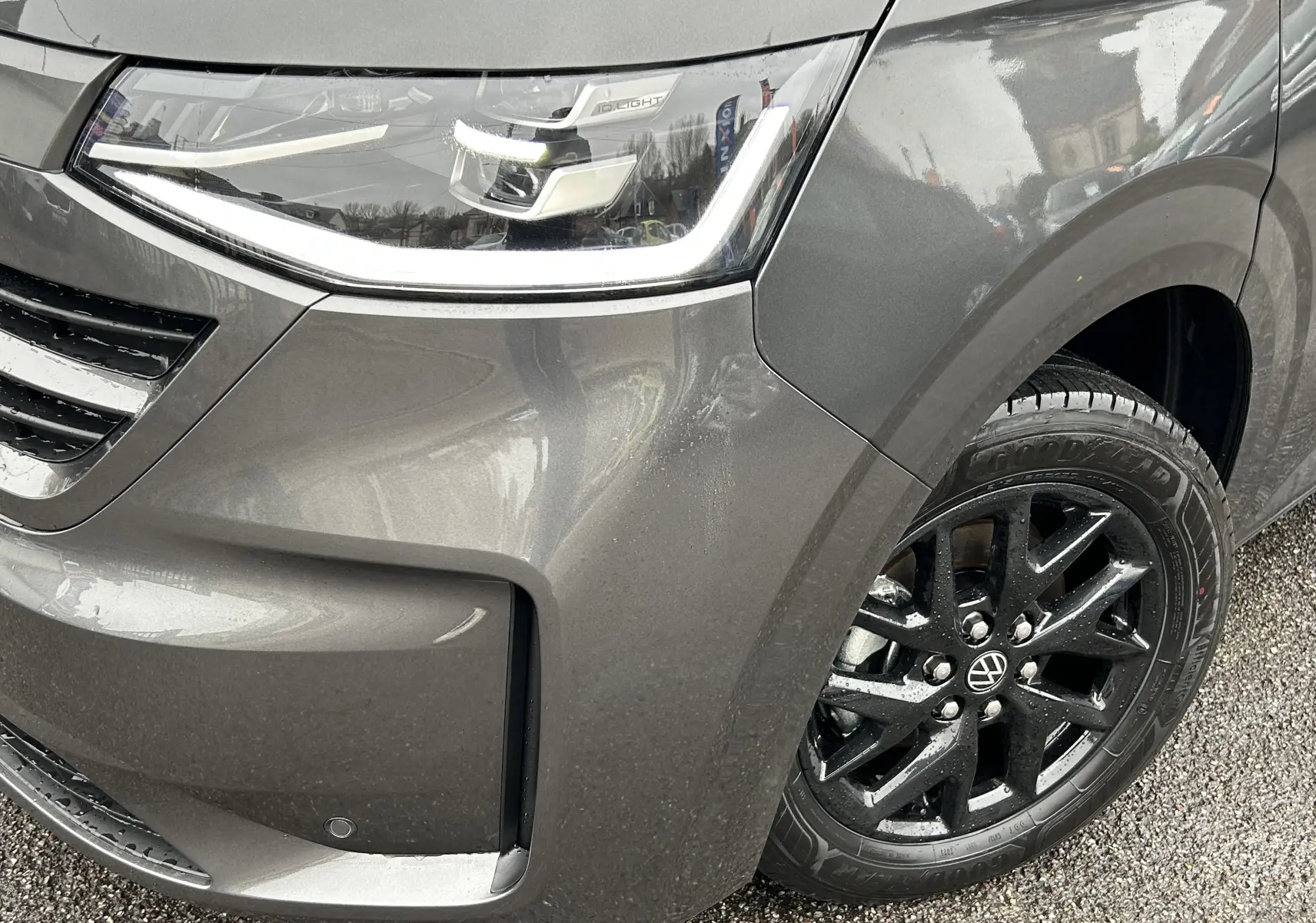 Gros plan sur l'avant droit du Volkswagen Transporter T7 Business graphite avec jante aluminium noire et phare LED Matrix.