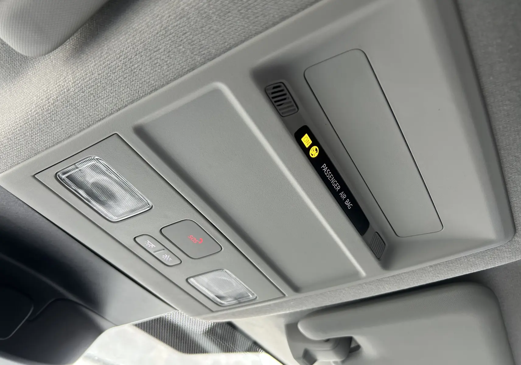 Vue intérieure du plafonnier gris clair du Volkswagen Transporter T7 avec éclairage et indicateur airbag passager activé.