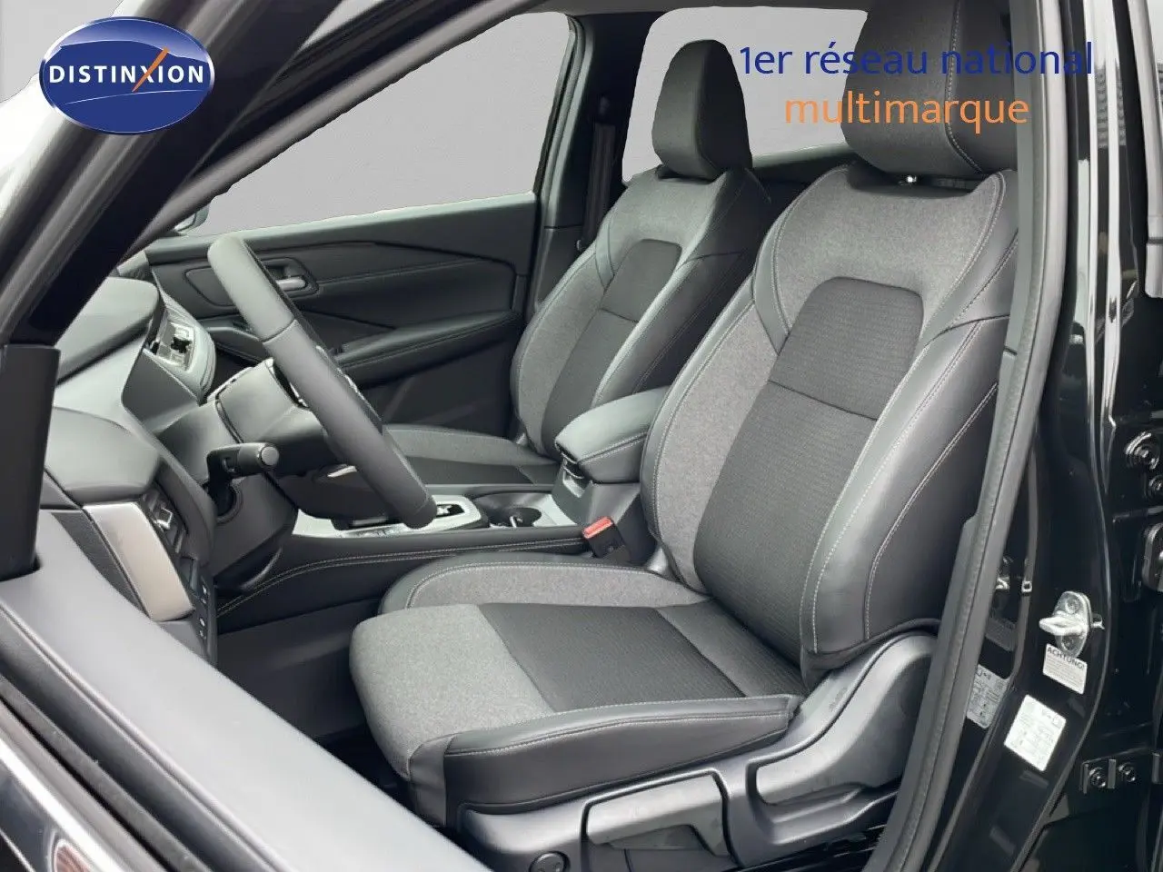 Vue intérieure côté conducteur du Nissan Qashqai 2025 noir perle métal, sièges tissu et cuir noir bicolore.