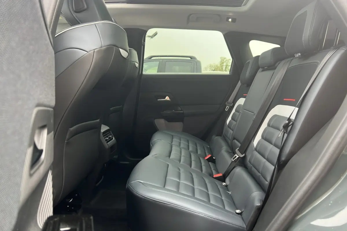 Vue intérieure arrière côté droit du Citroën C5 Aircross 2026, sièges cuir noir matelassés avec toit ouvrant panoramique.