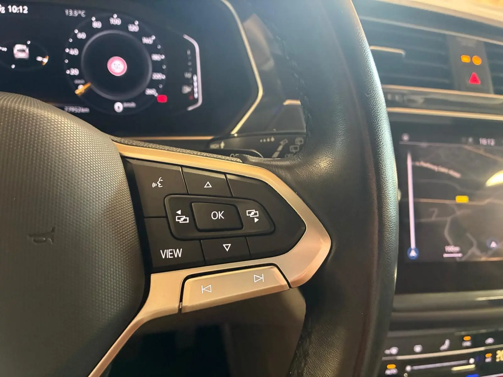Gros plan sur le volant multifonctions en cuir du Volkswagen Tiguan 2023 avec écran digital et commandes intégrées.