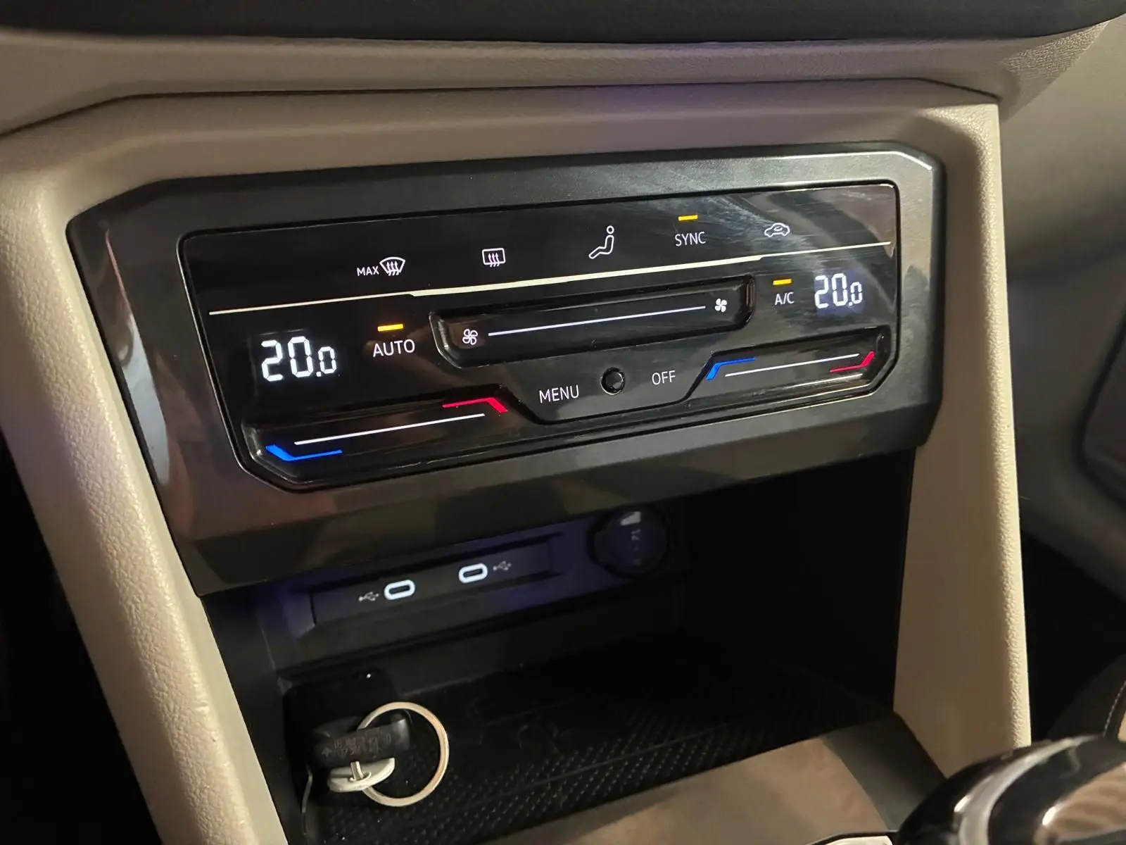 Gros plan sur la console centrale du Volkswagen Tiguan gris 2023, affichant la climatisation automatique à 20°C.