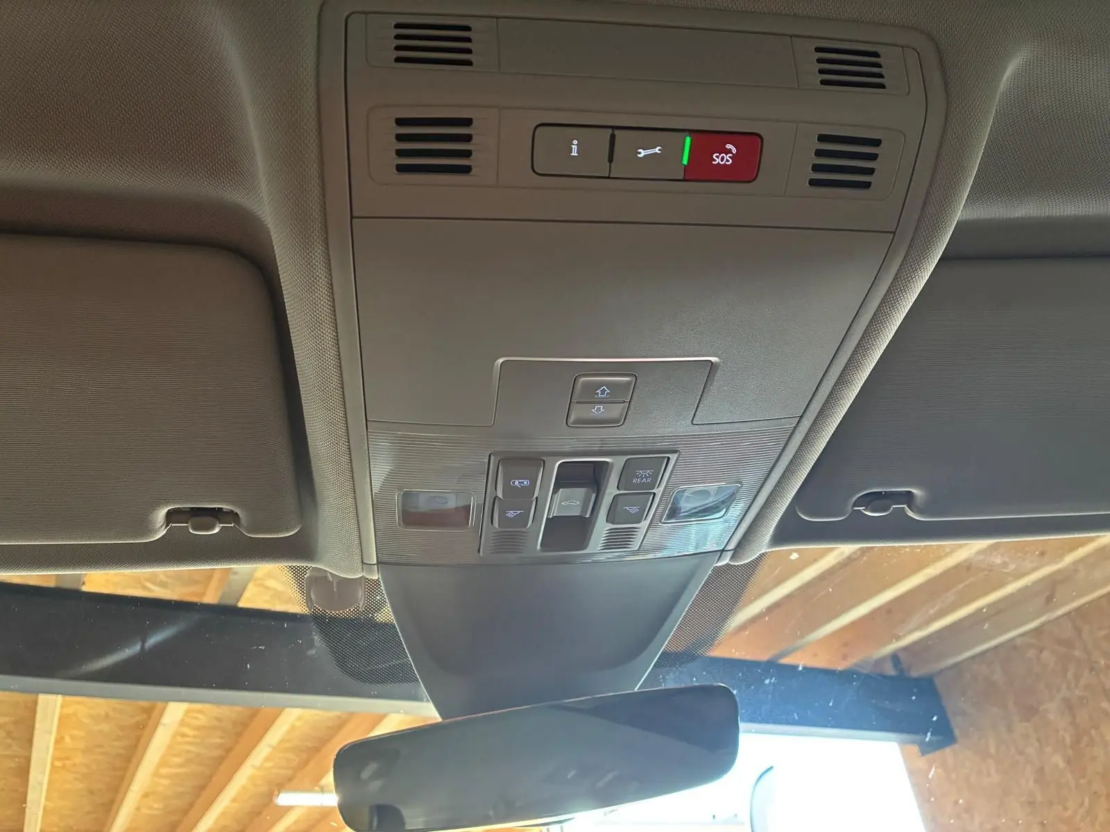 Vue intérieure du plafond avant du Volkswagen Tiguan 2023 gris, montrant les commandes du toit ouvrant et l'éclairage d'ambiance.