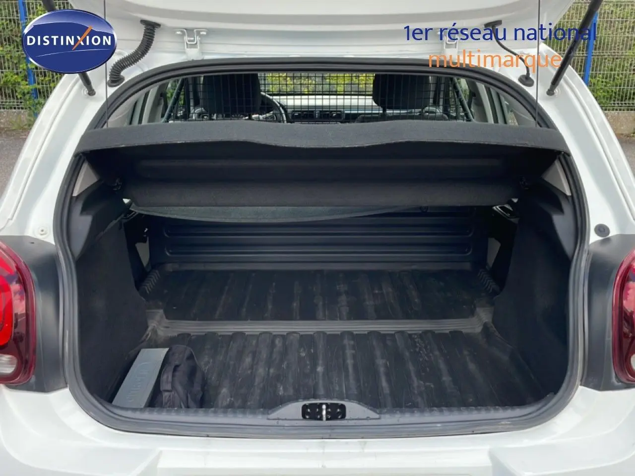 Coffre ouvert vu de l'arrière d'une Citroën C3 Société blanc banquise avec intérieur de chargement noir.