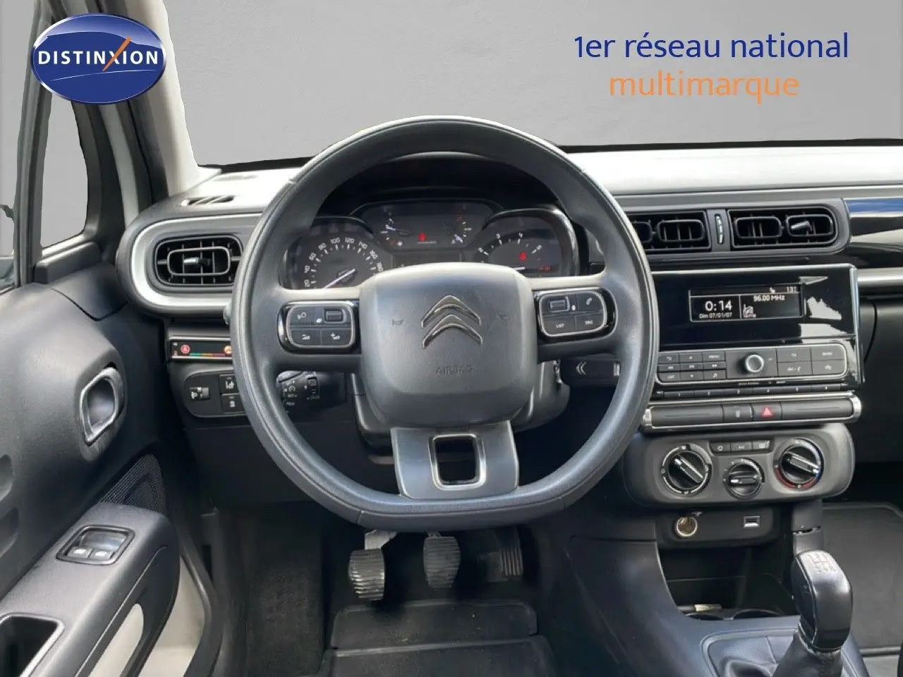 Vue intérieure centrée sur le volant et le tableau de bord gris noir de la Citroën C3 Société blanche de 2019.