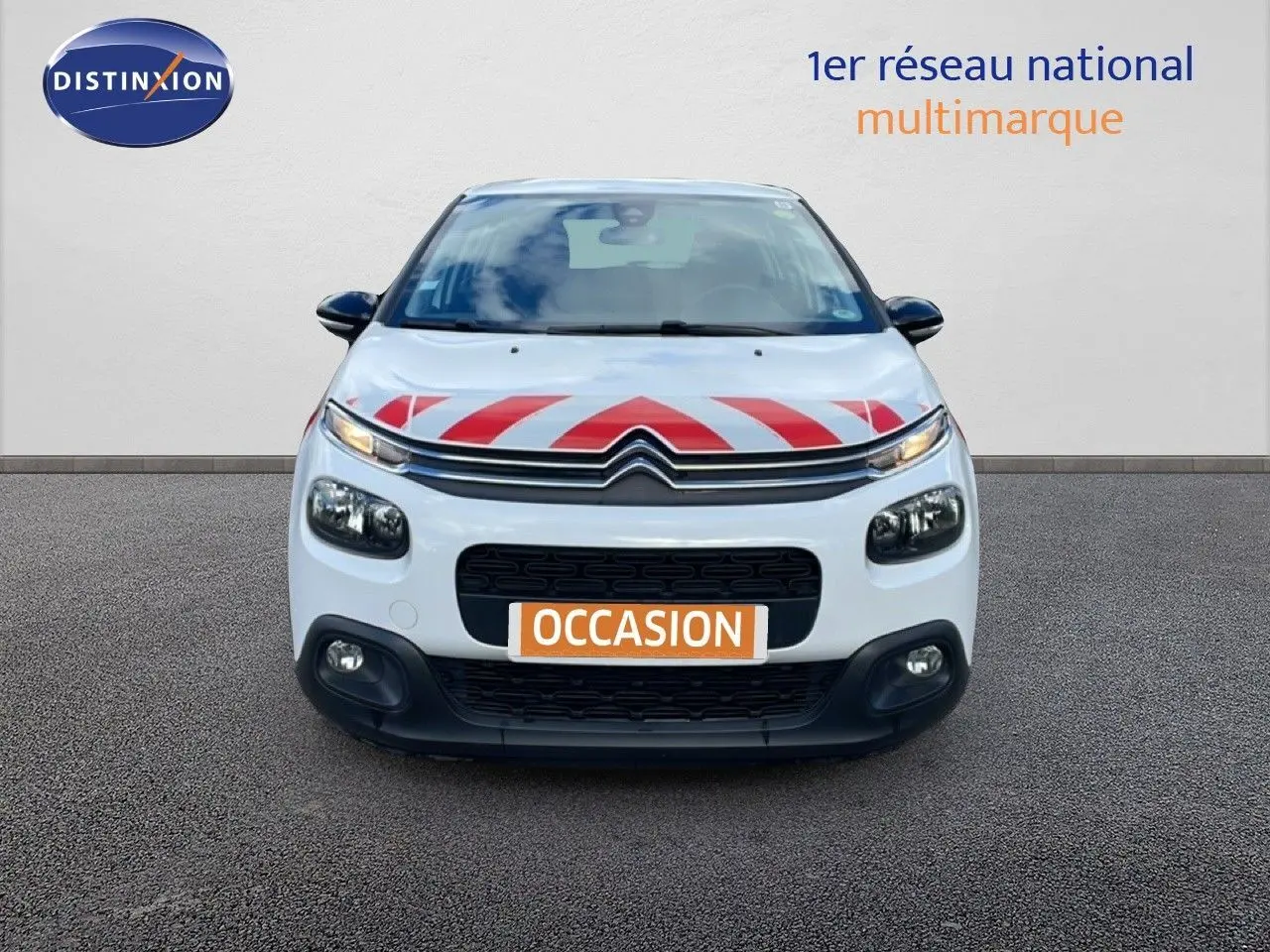 Vue frontale d'une Citroën C3 Société blanche avec marquage rouge sur le capot et plaque "OCCASION" visible.