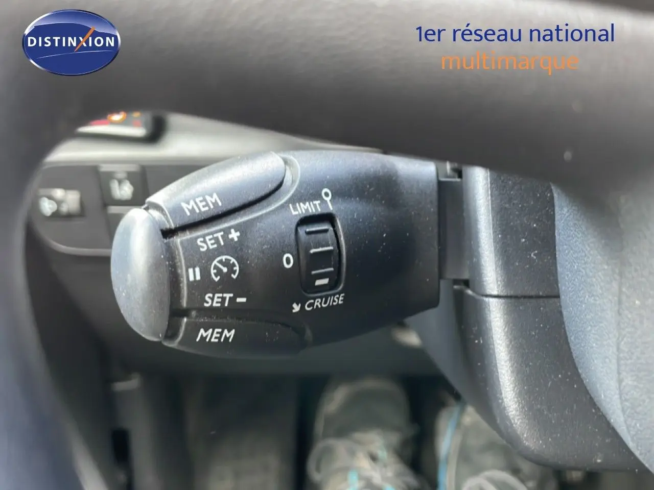 Gros plan sur la commande de régulateur de vitesse à gauche du volant d'une Citroën C3 Société blanc banquise.