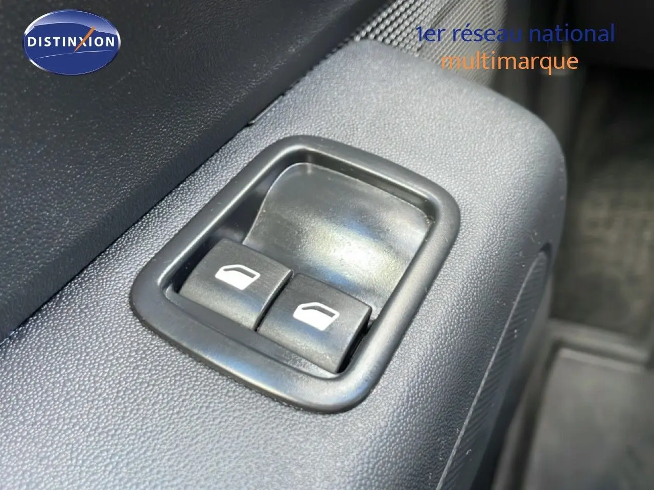 Gros plan sur les commandes de lève-vitres électriques côté conducteur d'une Citroën C3 Société blanche.