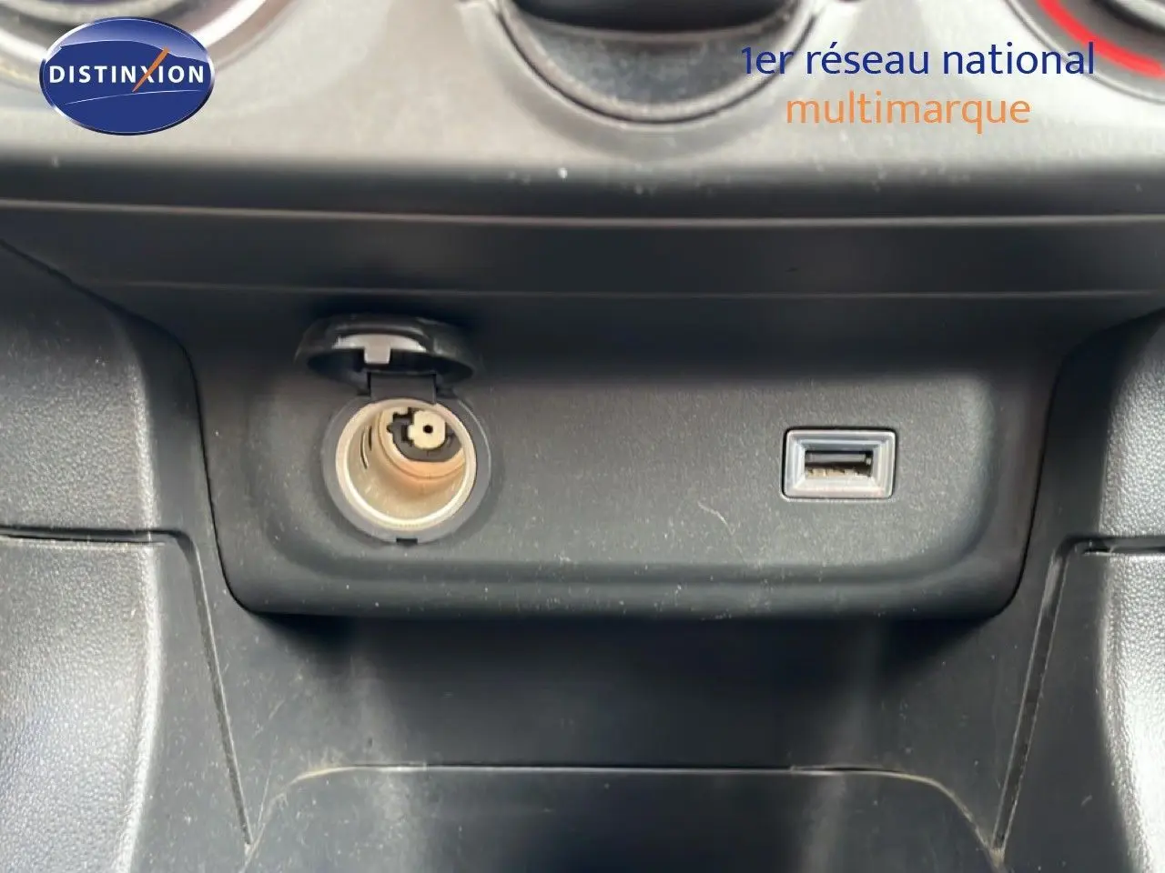 Prise allume-cigare et port USB sur la console centrale noire d’une Citroën C3 Société blanche, vue intérieure rapprochée.