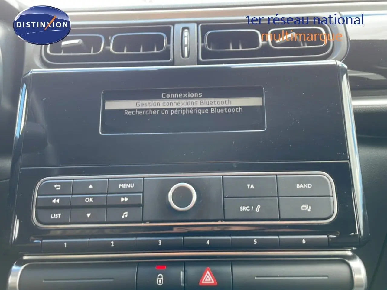 Vue rapprochée de la console centrale noire du Citroën C3 Société blanc banquise, affichant l'écran Bluetooth et les commandes radio.