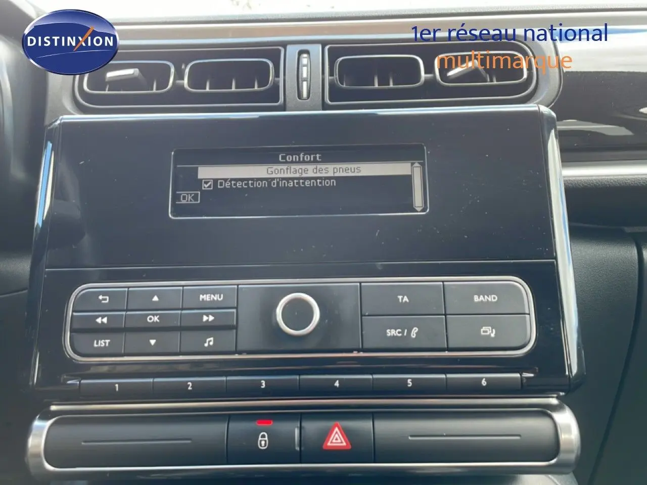 Vue rapprochée du tableau de bord de la Citroën C3 Société blanc banquise, affichant l'écran central et les commandes audio.