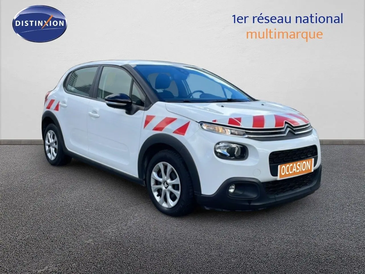 Citroën C3 Société blanc banquise vue 3/4 avant droit avec bandes rouges de signalisation sur capot et ailes.