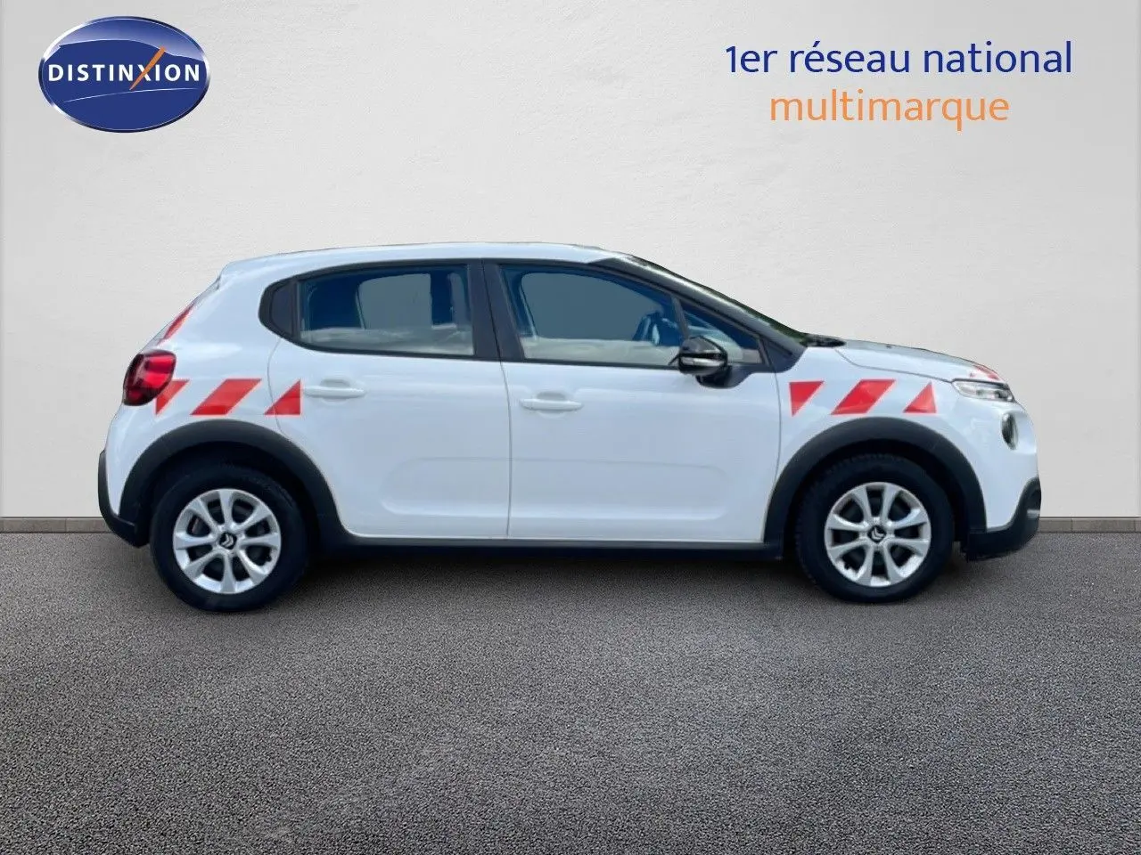 Profil droit d'une Citroën C3 Société blanche avec bandes rouges diagonales sur ailes avant et arrière.