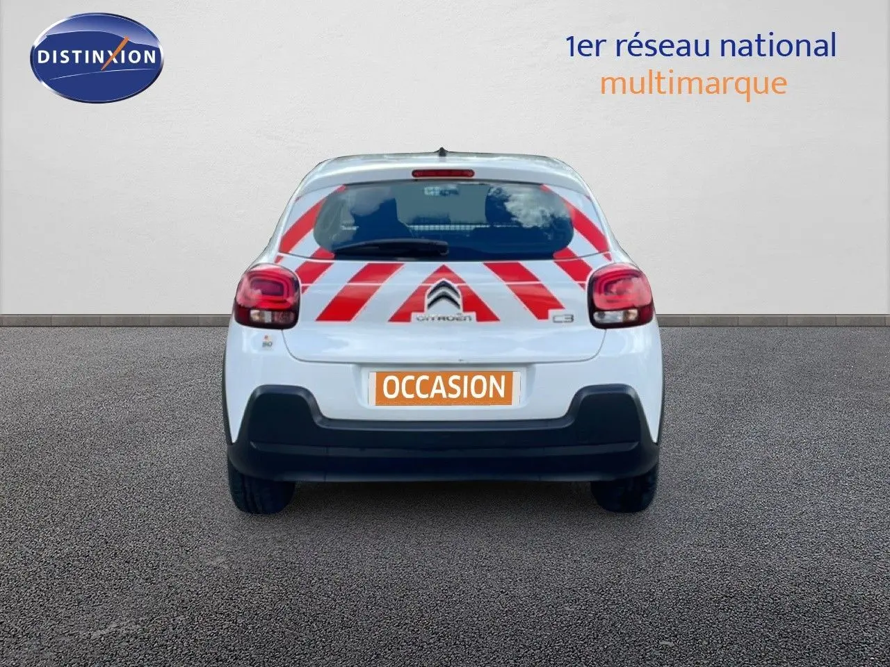 Vue arrière d'une Citroën C3 Société blanche avec bandes rouges diagonales de signalisation sur le hayon.