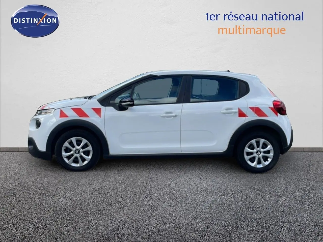 Vue de profil droit d'une Citroën C3 Société blanche avec bandes rouges diagonales sur ailes avant et arrière.