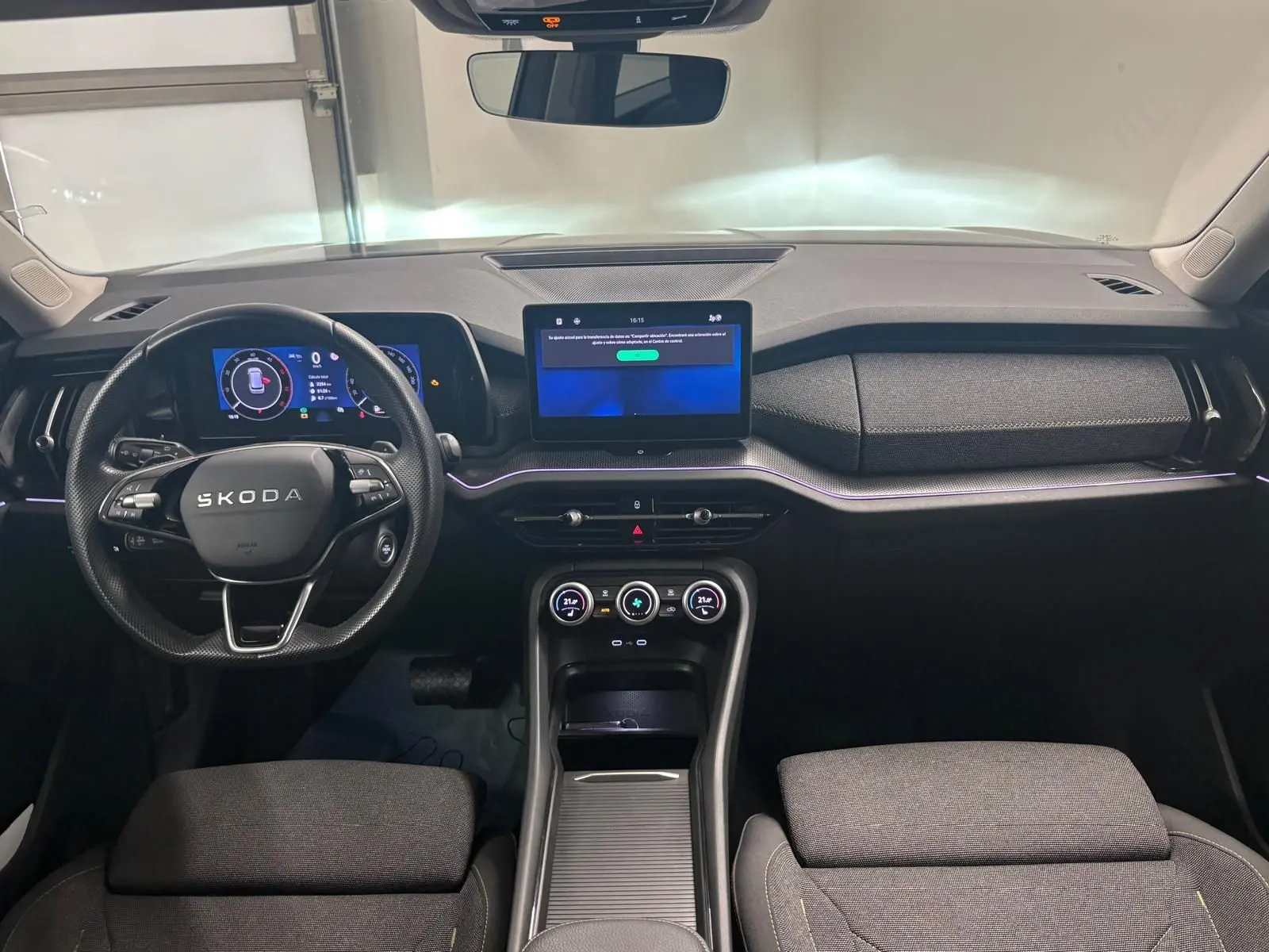 Vue intérieure frontale du Skoda Kodiaq 2025 gris graphite, mettant en valeur le tableau de bord numérique et l’écran tactile central.