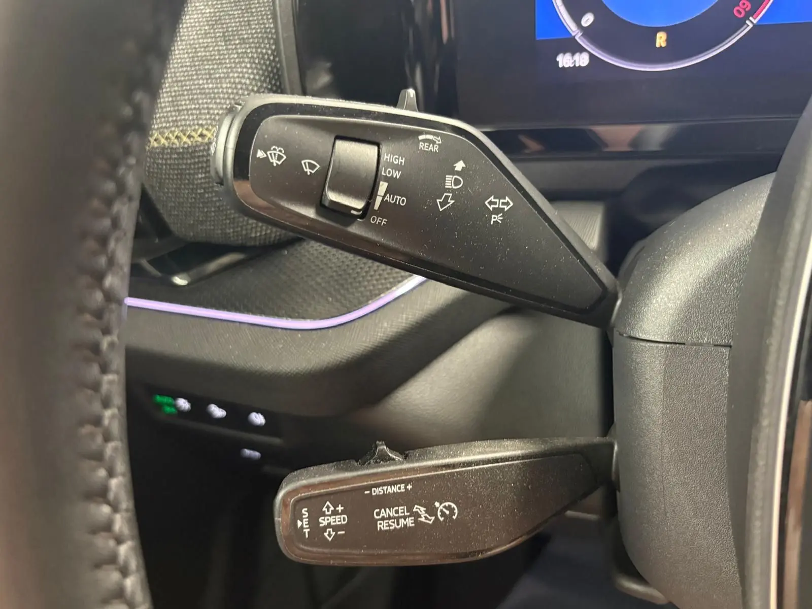 Gros plan sur les commandes au volant du Skoda Kodiaq 2025, avec leviers de clignotants et régulateur de vitesse.