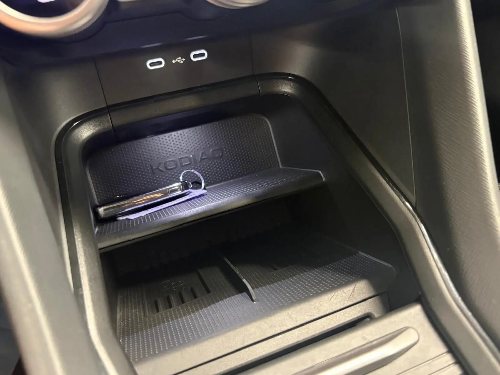 Détail de la console centrale du Skoda Kodiaq 2025, avec zone de rangement et ports USB visibles.