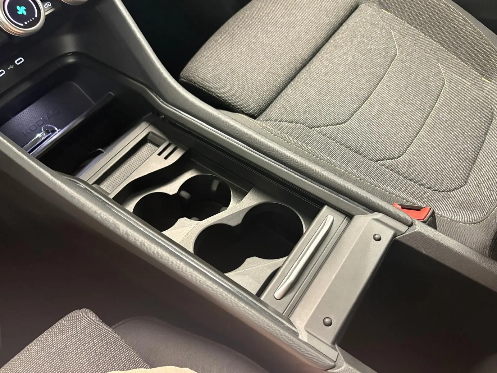 Vue rapprochée de la console centrale grise avec porte-gobelets et siège tissu gris du Skoda Kodiaq 2025.